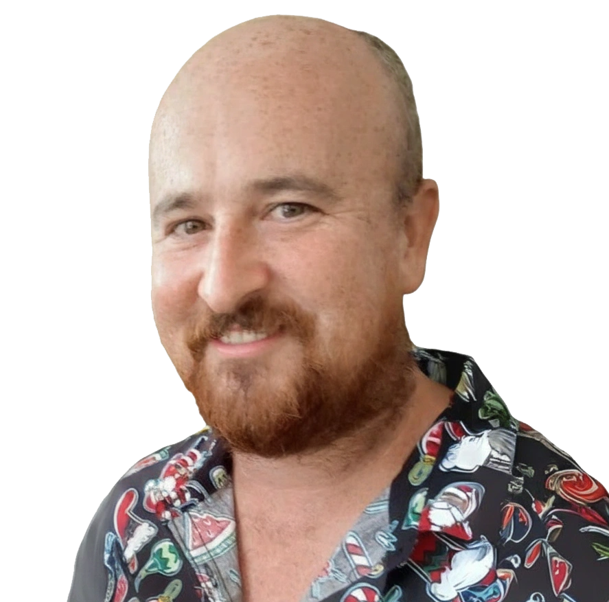 Smiling bald man with a red beard wearing a colorful tropical shirt, portrait photo on a dark background